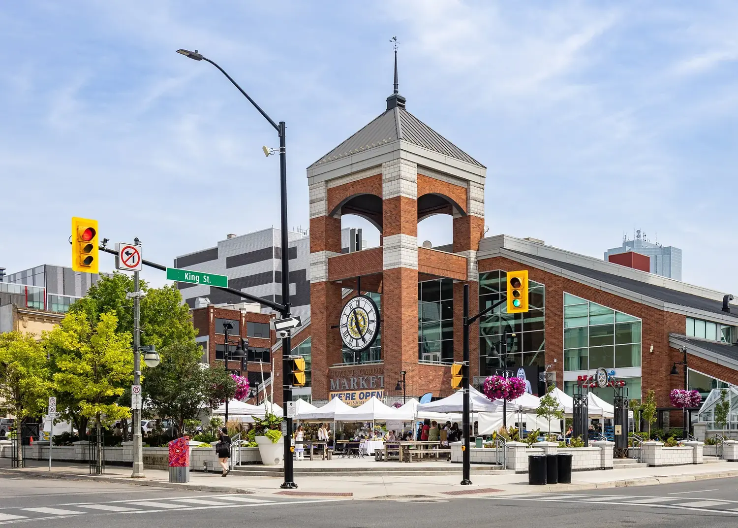 Covent Garden Market in downtown London, Ontario, its brick clock tower and outdoor stalls seen from King Street in daylight.